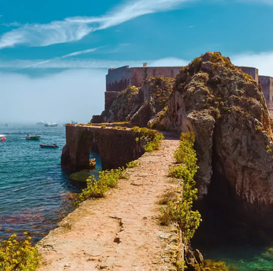 Stone path leading to the Fortress of São João Baptista on Berlenga Island, surrounded by turquoise Atlantic waters and boats.