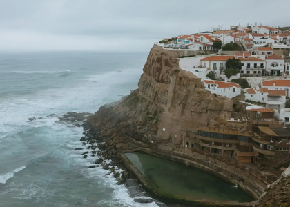 Azenhas do Mar, a cliffside village in Portugal with white houses, red rooftops, and a natural ocean pool by the Atlantic coast.
