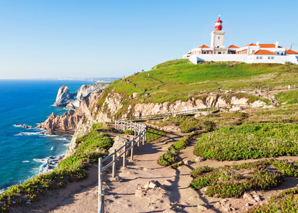 Scenic view of Cabo da Roca lighthouse on the cliffs of Portugal’s westernmost point, overlooking the Atlantic Ocean.