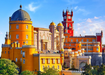 Panoramic view of the colorful Pena Palace in Sintra, Portugal, under a clear blue sky.