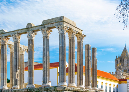View of the Roman Temple of Évora in Portugal, with its Corinthian columns and the Cathedral of Évora in the background.