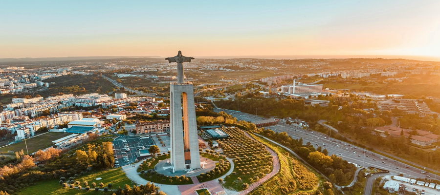 Drone shot of the Cristo Rei statue in Almada overlooking Lisbon during sunset