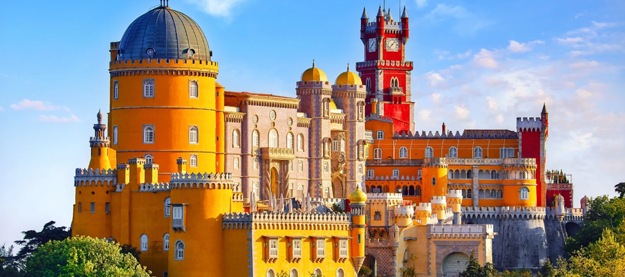 Panoramic view of the colorful Pena Palace in Sintra, Portugal, under a clear blue sky.