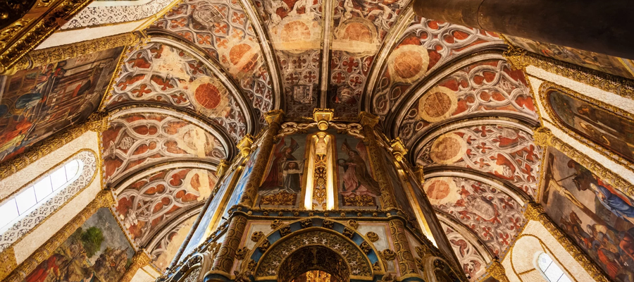 Interior view of the Charola in the Convent of Christ, Tomar, Portugal, showcasing its richly decorated vaults and frescoes.
