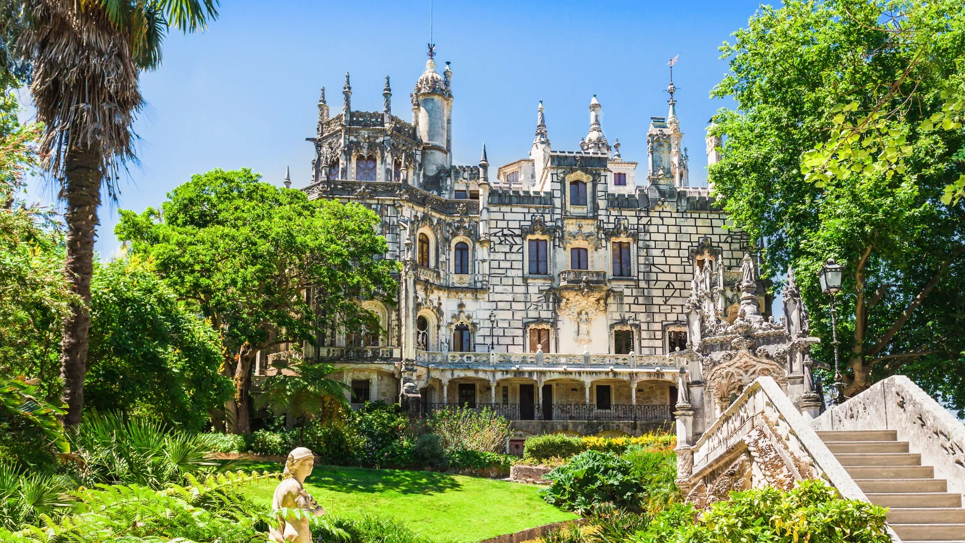 Main palace of Quinta da Regaleira surrounded by lush gardens in Sintra, Portugal.