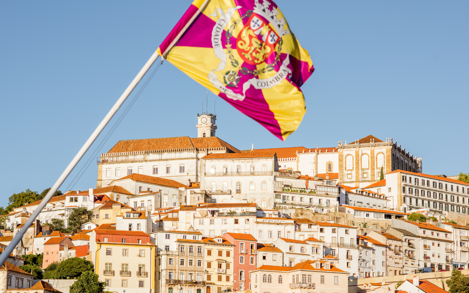 Flag of Coimbra city in front of the historic University of Coimbra, a UNESCO World Heritage Site in Portugal.
