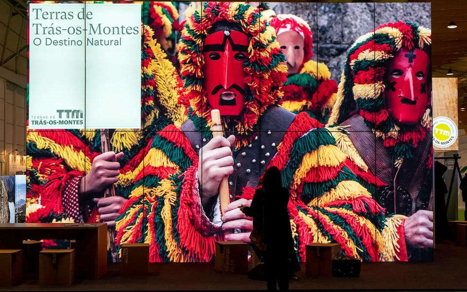 Traditional Careto costumes from Trás-os-Montes displayed at Lisbon Travel Market (BTL), featuring colorful wool suits and wooden masks.