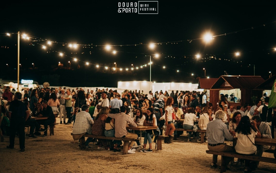 Evening at Douro & Porto Wine Festival with outdoor tables, string lights, and lively crowd
