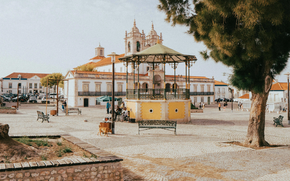 Main square in Nazaré with bandstand, Church of Our Lady of the Sands and people walking