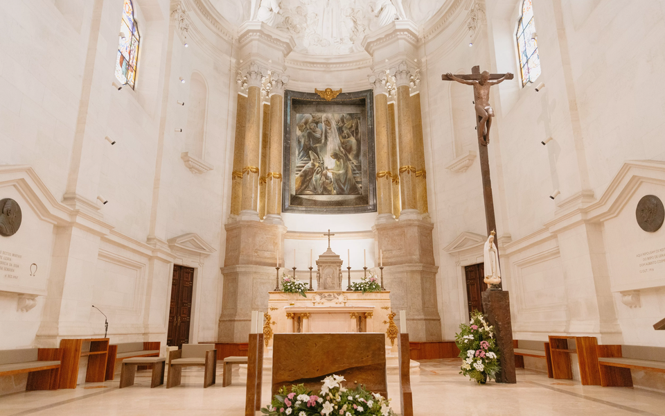 View of the altar inside the Fátima Basilica with crucifix, painting and flowers