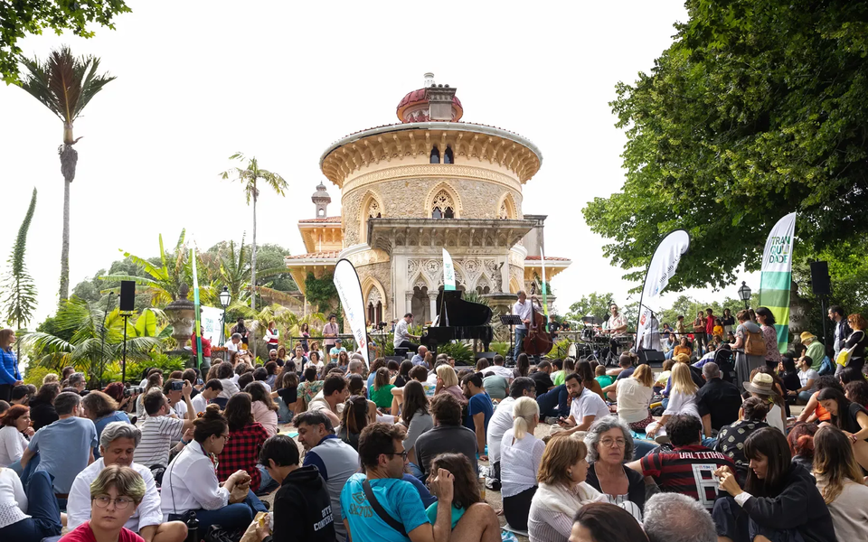 Large crowd attending a jazz concert in front of Monserrate Palace in Sintra during the 2023 Jazz em Monserrate festival, with live music and lush garden surroundings.