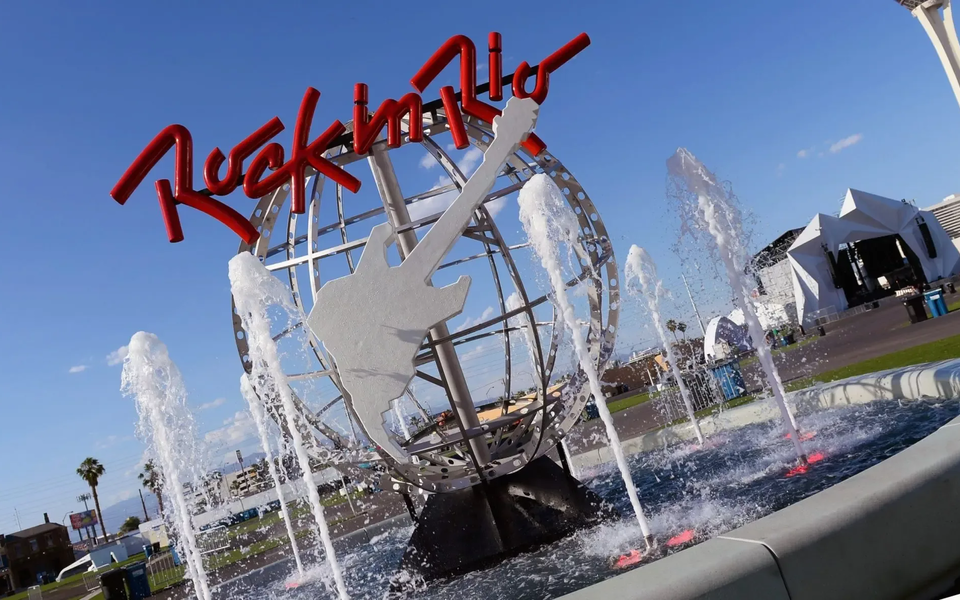 Rock in Rio Las Vegas monument with giant guitar and water fountain in front of concert stage and blue sky