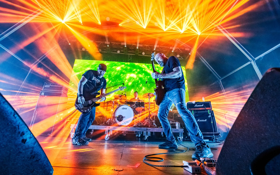 Rock band performing live at SonicBlast Festival in Portugal with vibrant stage lights and energetic atmosphere.