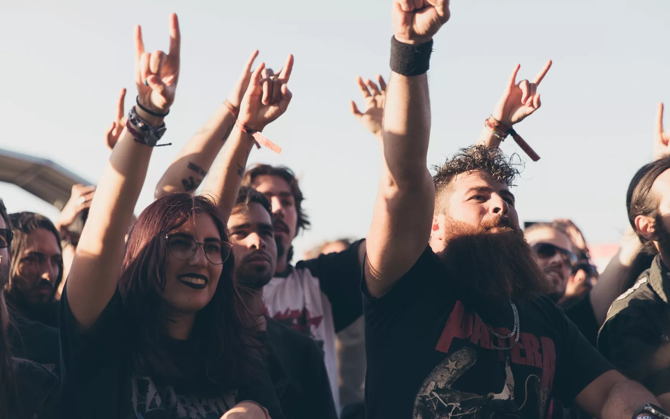 Fans at Vagos Metal Fest raising their hands and enjoying a live metal concert in Portugal.