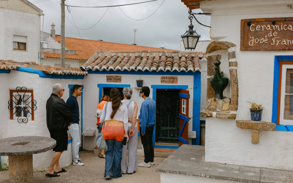 Visitors explore the miniature village at Aldeia-Museu de José Franco in Sobreiro, Portugal, a cultural site near Ericeira with traditional houses and artisan ceramics.