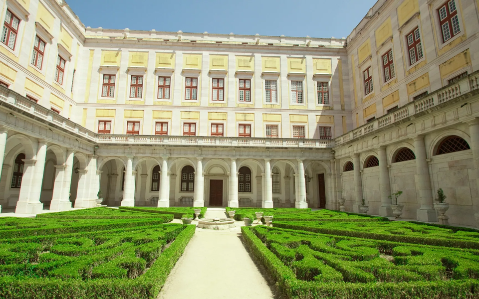 Claustro do Palácio Nacional de Mafra com jardim geométrico e arquitetura barroca portuguesa.