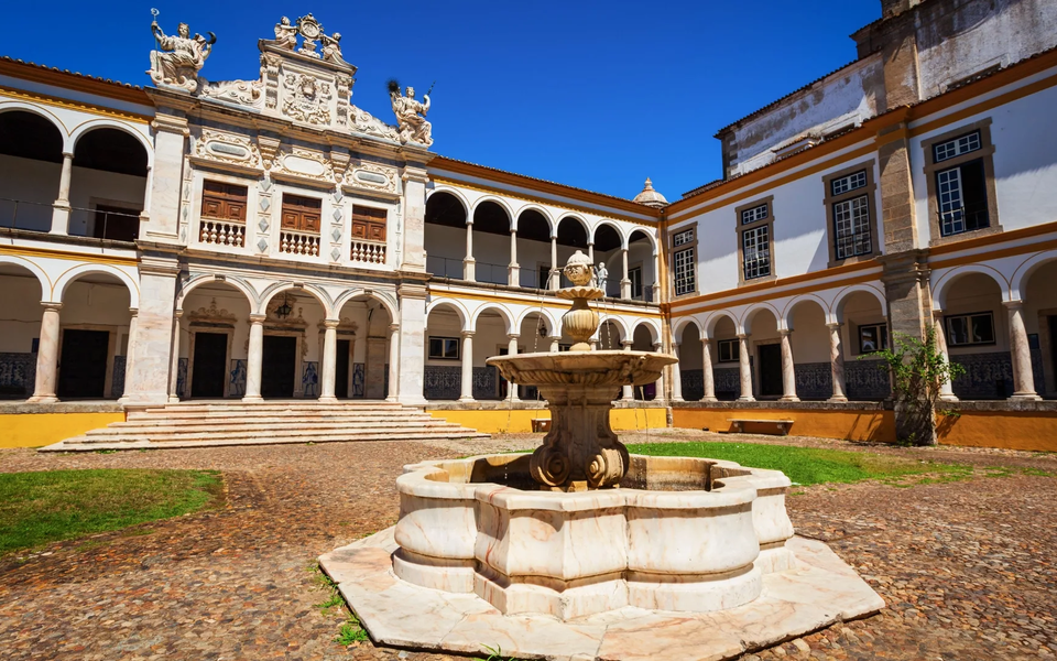 University of Évora, Renaissance courtyard of Colégio do Espírito Santo with fountain and arcades, Portugal.
